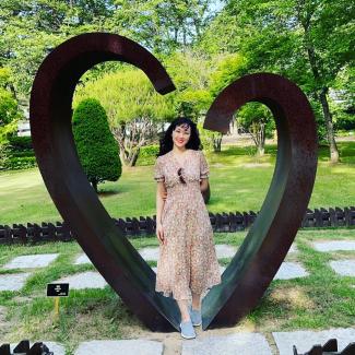 Tricia Park in front of a heart sculpture in Korea