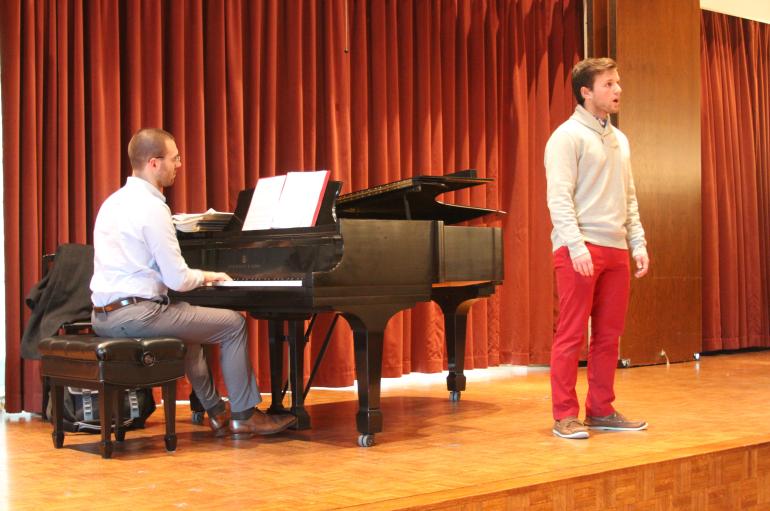 A young man performs with piano on stage in Fulton Recital Hall