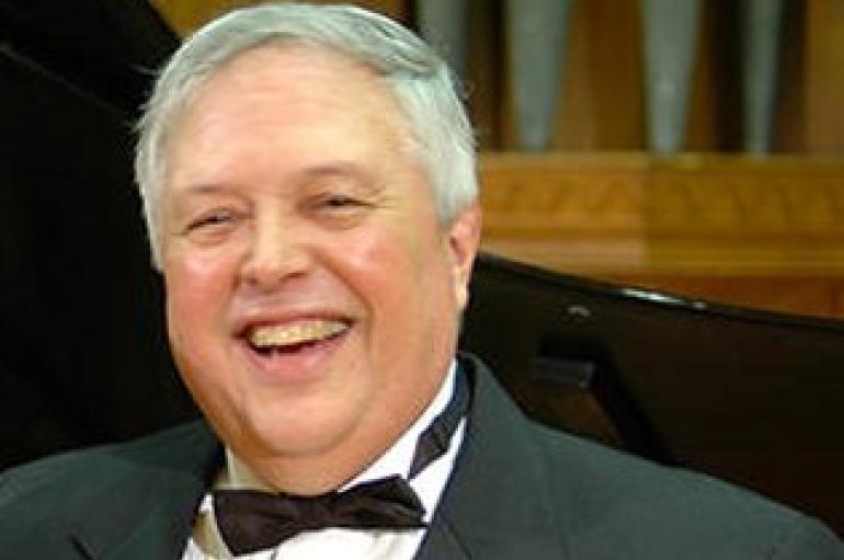 Kurt Hansen wearing a bow tie and tuxedo, chuckling