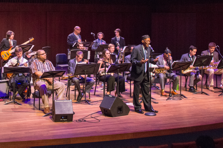 Mwata Bowden on stage addressing the audience in front of the jazz x-tet