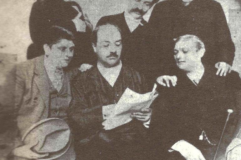 Archive photo showing a group of Italian men sitting around a newspaper in the late 1800s. Alessandro Moreschi is on the bottom left, and Giovanni Cesari is on the bottom right.
