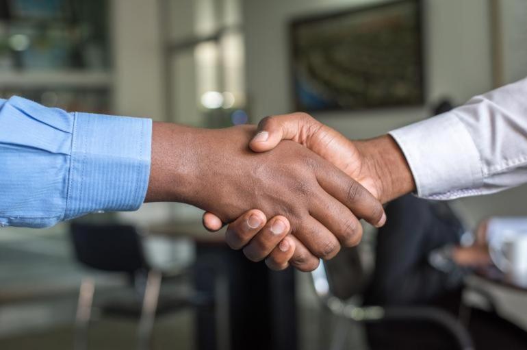 A close-up shot of the hands of two people shaking hands