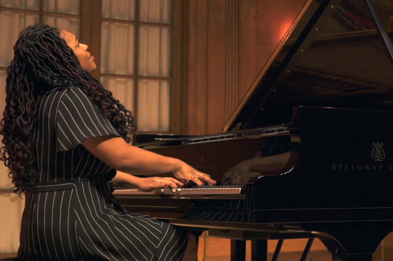 A woman sitting at a piano, looking upward