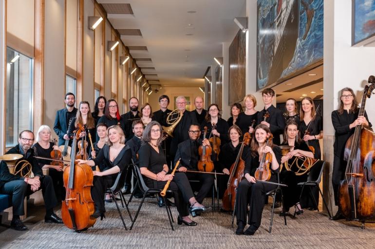 A large group of people holding musical instruments