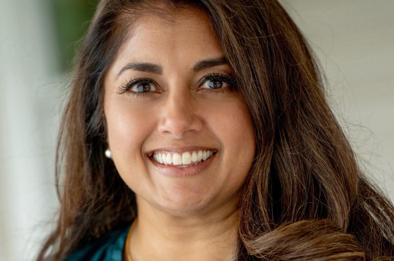 Headshot of a smiling woman in a teal blouse