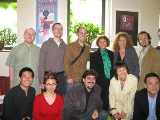 A group of 12 people smile at the camera.