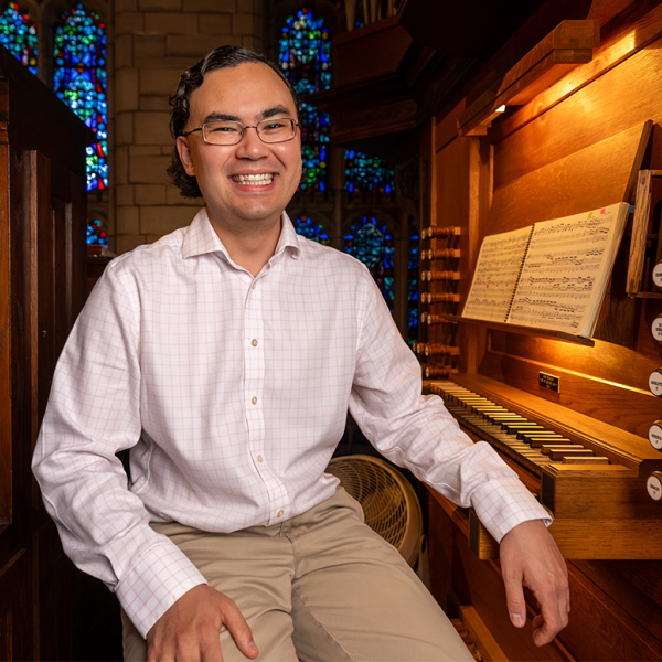 Jacob Reed smiles, sitting next to the Reneker Organ keyboard. Photo by Jason Smith